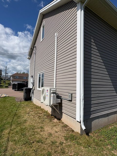 Gree mini split heat pump outdoor unit and electrical disconnect on house exterior